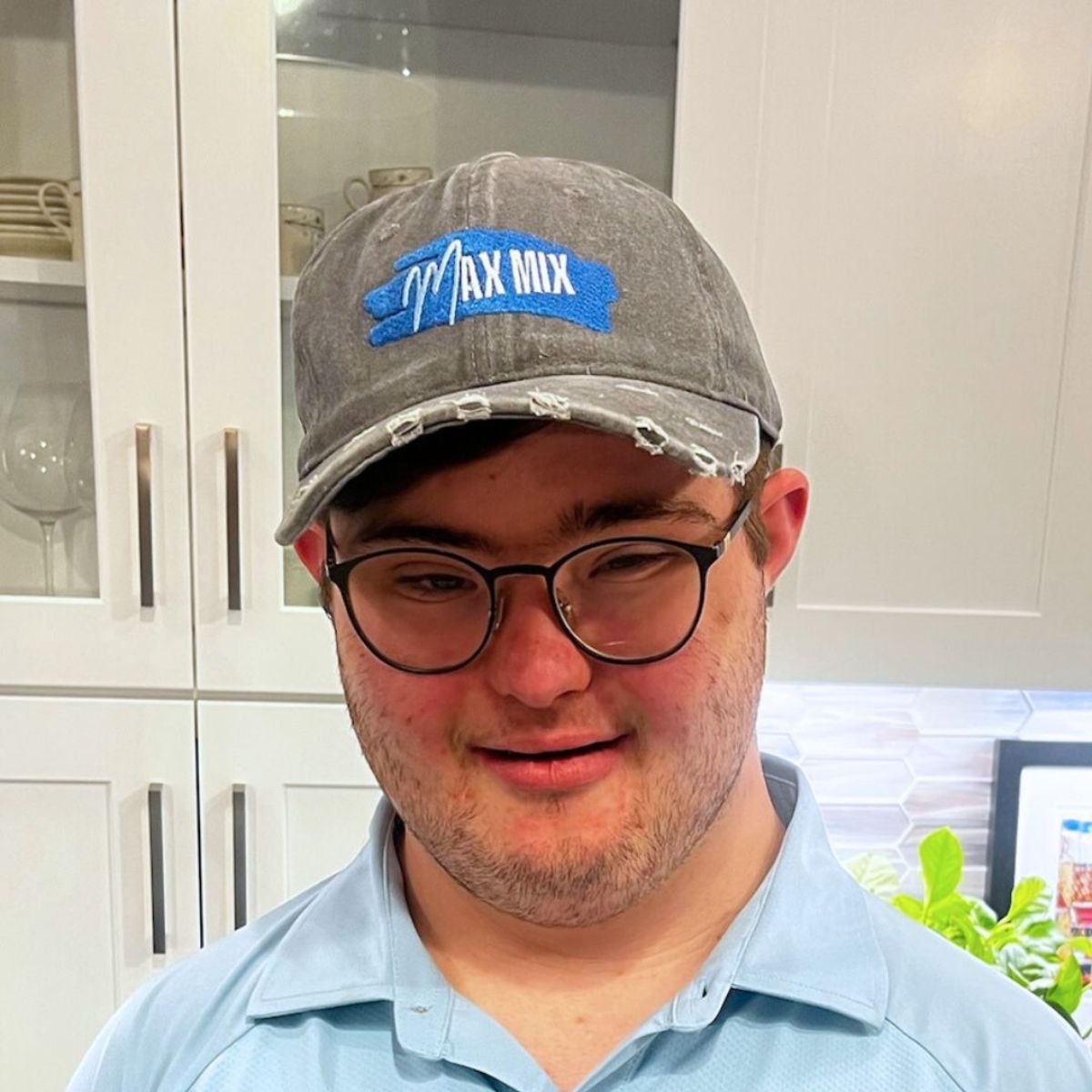 A picture of Max Mix founder Max, wearing a grey trucker hat with company logo, and smiling.
