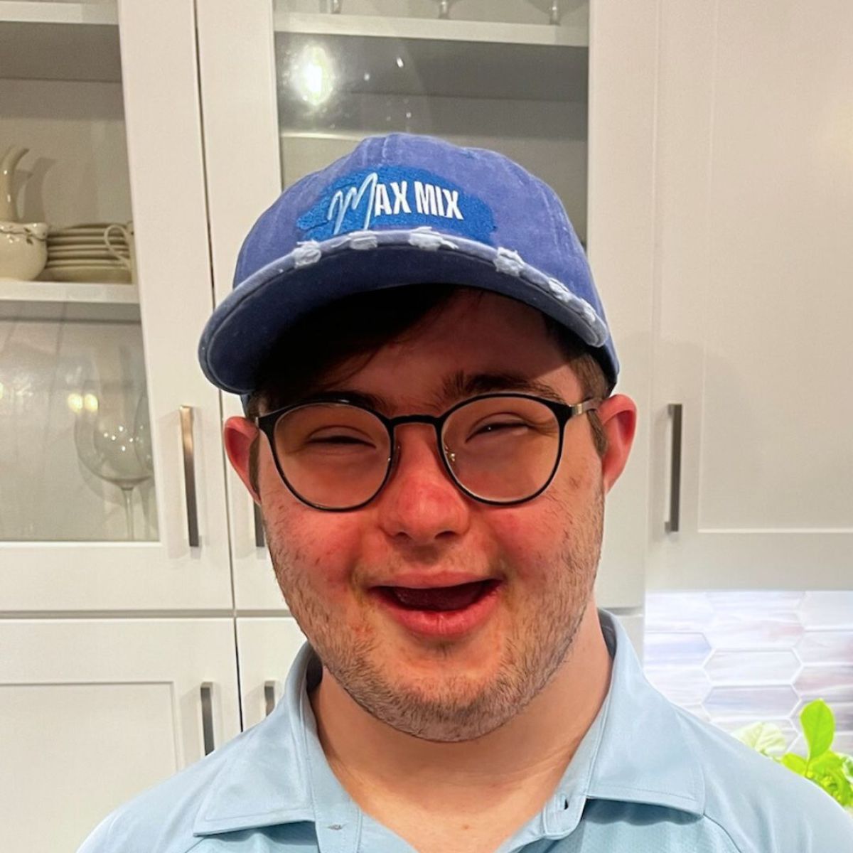 A picture of Max Mix founder Max, wearing a blue trucker hat with company logo, and smiling into the camera.