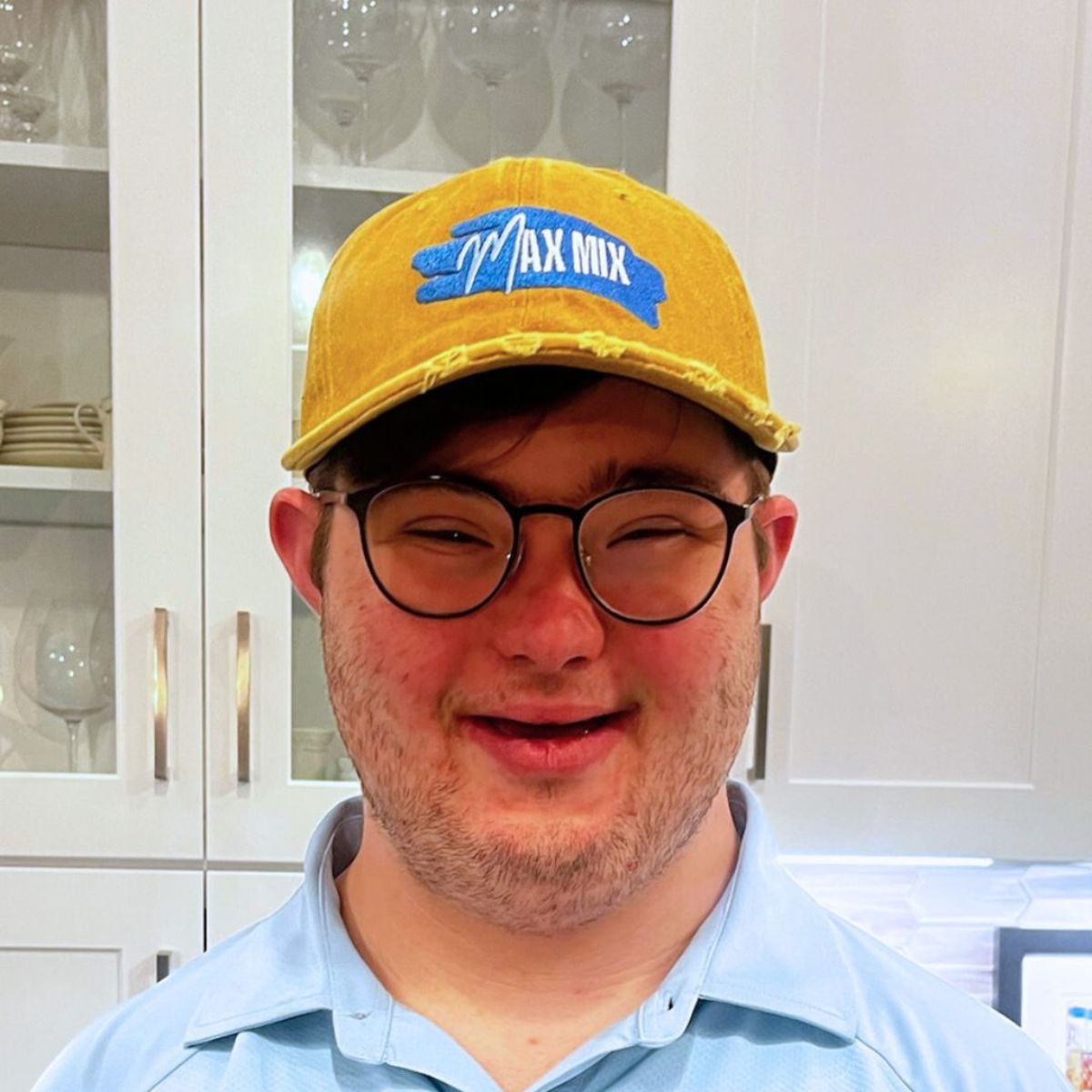 A picture of Max Mix founder Max, wearing a yellow trucker hat with company logo, and smiling into the camera.