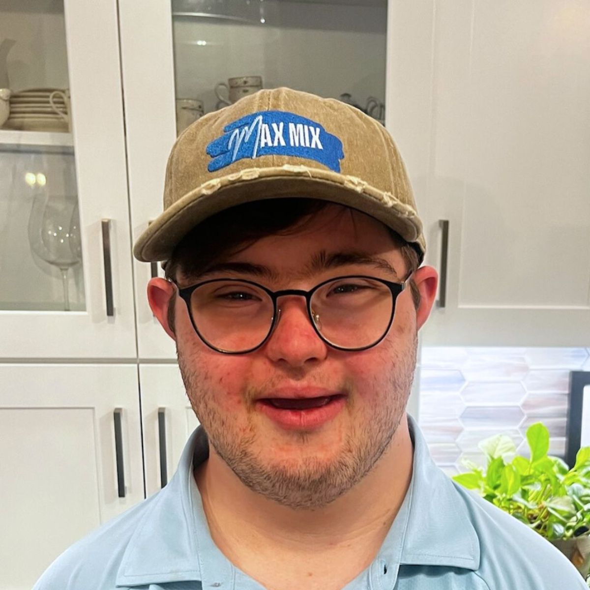 A picture of Max Mix founder Max, wearing a beige trucker hat with company logo, and smiling into the camera.
